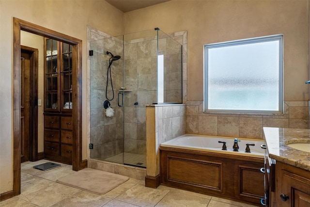 full bath with a garden tub, a shower stall, tile patterned floors, and vanity