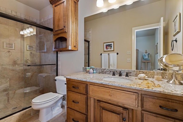 bathroom with toilet, a stall shower, and vanity