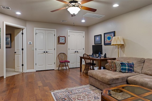 living room with wood finished floors, visible vents, and recessed lighting