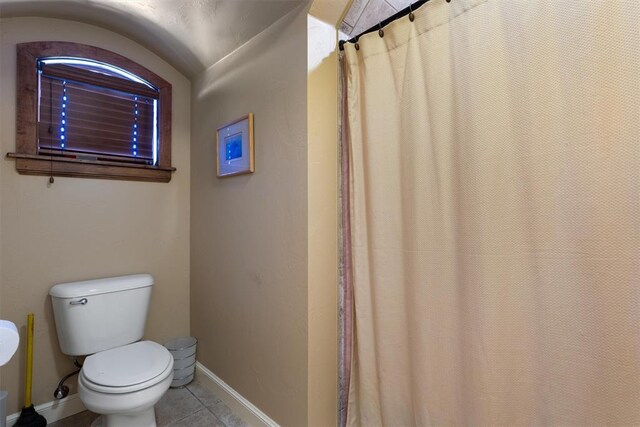 full bathroom with tile patterned flooring, baseboards, and toilet