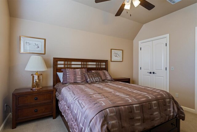 bedroom with a closet, visible vents, light carpet, vaulted ceiling, and baseboards