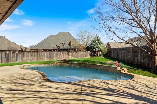 view of pool with a patio, a lawn, and a fenced backyard