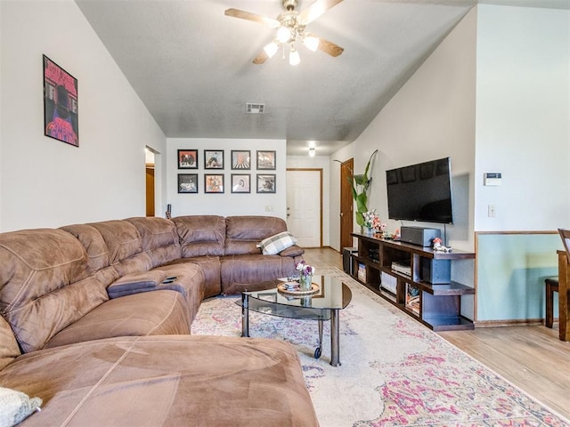 living area featuring a ceiling fan, visible vents, and wood finished floors