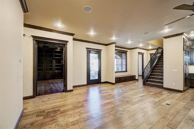 interior space with crown molding, stairway, ceiling fan, wood finished floors, and baseboards