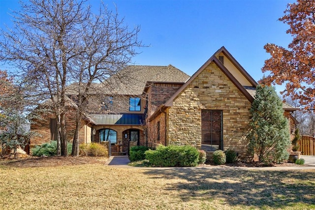 view of front of property featuring stone siding and a front lawn