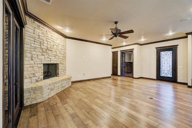 unfurnished living room with light wood-type flooring, baseboards, a fireplace, and ornamental molding