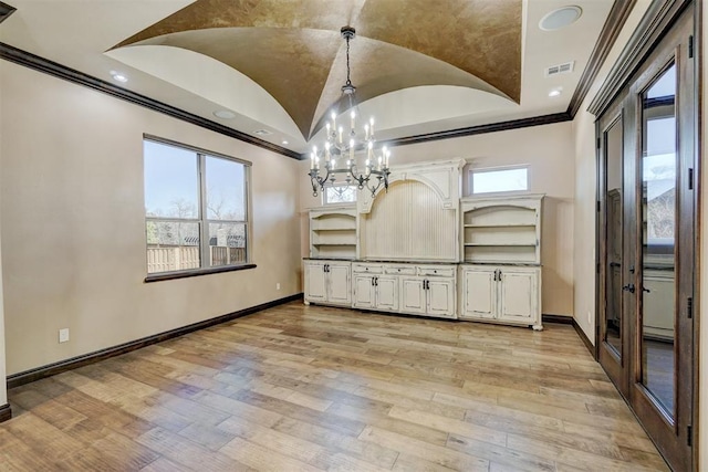 interior space with light wood-style floors, crown molding, vaulted ceiling, and baseboards