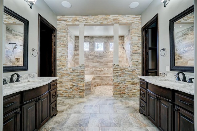 bathroom with two vanities, a sink, and walk in shower