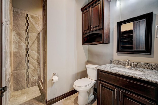 bathroom with toilet, vanity, baseboards, a shower stall, and tile patterned floors