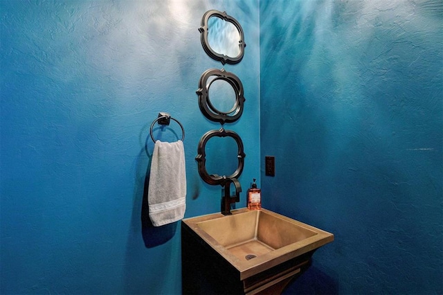 bathroom featuring a textured wall and a sink