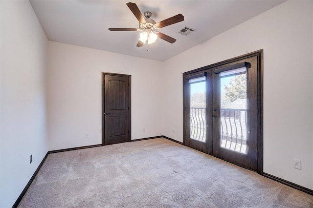 empty room with baseboards, visible vents, light colored carpet, and french doors