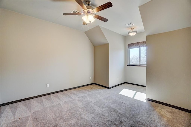 additional living space featuring ceiling fan, light colored carpet, visible vents, baseboards, and vaulted ceiling