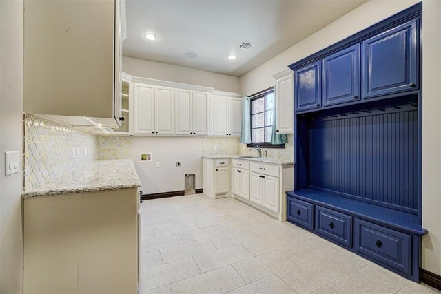 interior space featuring cabinet space, visible vents, hookup for a washing machine, hookup for an electric dryer, and a sink