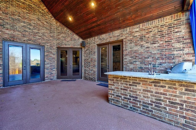 view of patio / terrace featuring an outdoor kitchen, a sink, and french doors