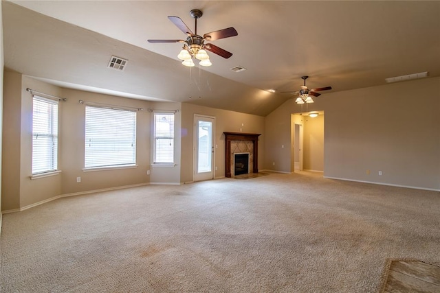 unfurnished living room with light carpet, a fireplace with flush hearth, visible vents, and a ceiling fan