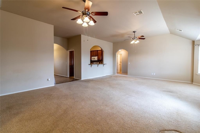 unfurnished room with light carpet, visible vents, arched walkways, and ceiling fan