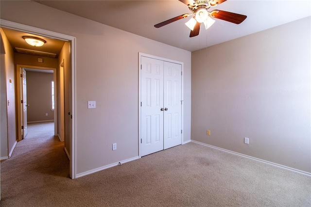 unfurnished bedroom featuring a closet, carpet, a ceiling fan, and baseboards