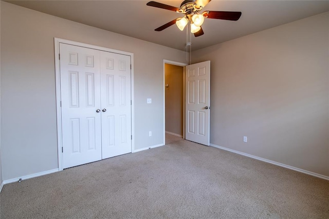 unfurnished bedroom featuring a closet, carpet flooring, ceiling fan, and baseboards