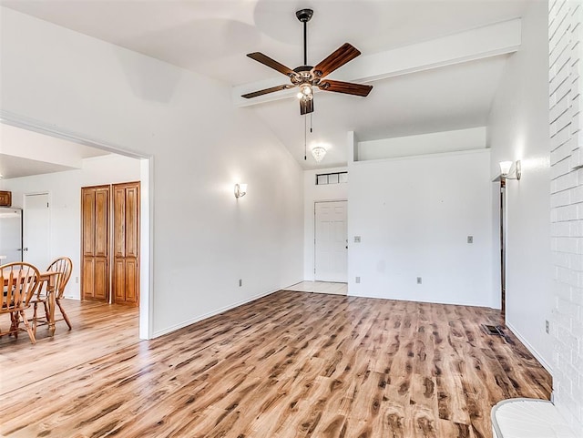 unfurnished living room featuring vaulted ceiling with beams, light wood-style floors, visible vents, and a ceiling fan