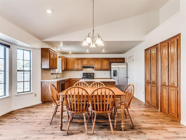 dining area with a chandelier, lofted ceiling, light wood-style flooring, and recessed lighting