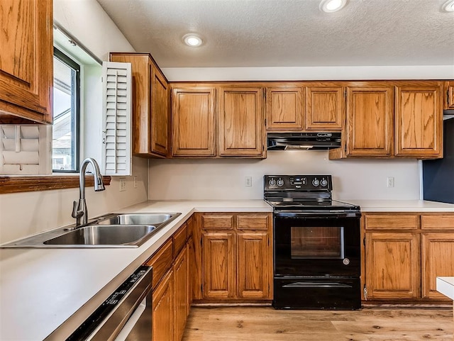 kitchen featuring black electric range, brown cabinets, stainless steel dishwasher, a sink, and under cabinet range hood