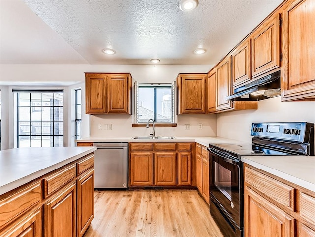 kitchen with under cabinet range hood, a sink, stainless steel dishwasher, black electric range oven, and light wood finished floors