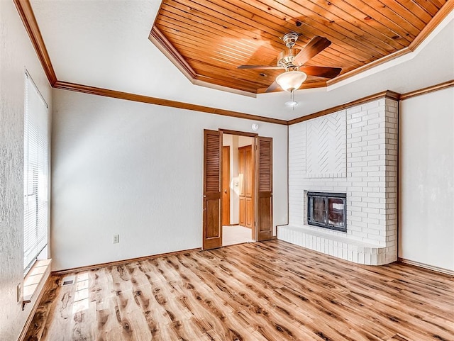 unfurnished living room featuring crown molding, a fireplace, a raised ceiling, wood finished floors, and wooden ceiling