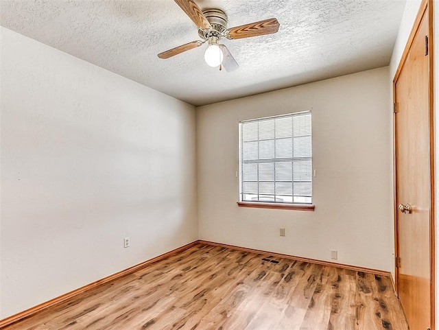 unfurnished bedroom with a ceiling fan, a textured ceiling, baseboards, and wood finished floors