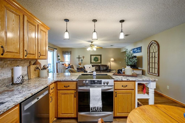 kitchen featuring stainless steel appliances, hanging light fixtures, backsplash, open floor plan, and a peninsula