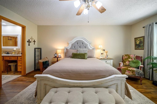 bedroom featuring ensuite bath, a textured ceiling, a ceiling fan, and wood finished floors