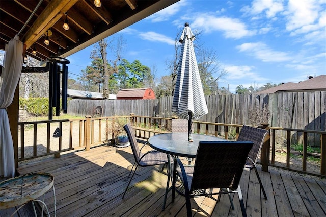 wooden terrace featuring a fenced backyard and outdoor dining area