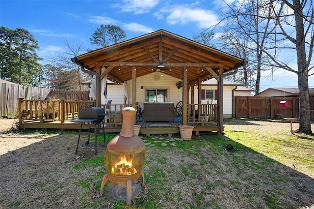 view of yard featuring a fenced backyard, a wooden deck, and a ceiling fan