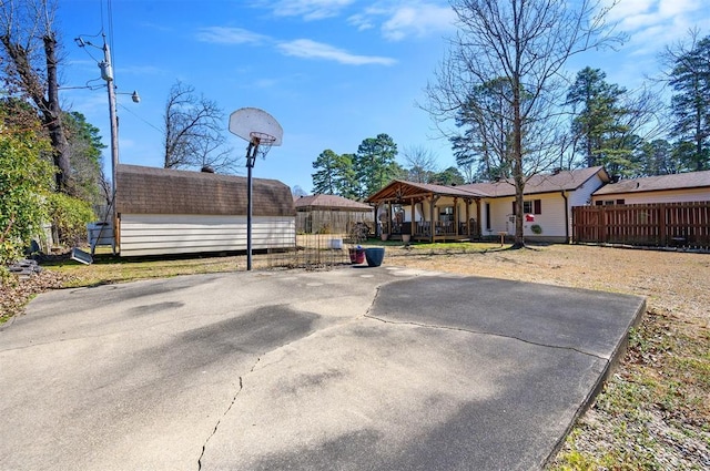 view of yard featuring an outbuilding, a storage shed, covered porch, and fence