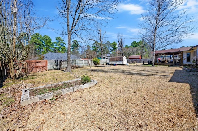 view of yard featuring an outbuilding, a garden, a fenced backyard, and a storage unit