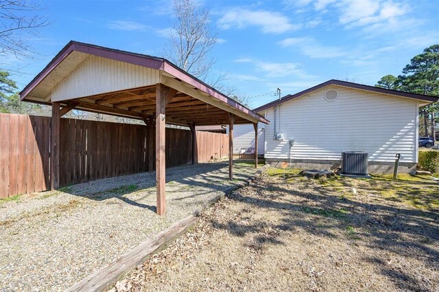 exterior space with a carport, fence, and driveway