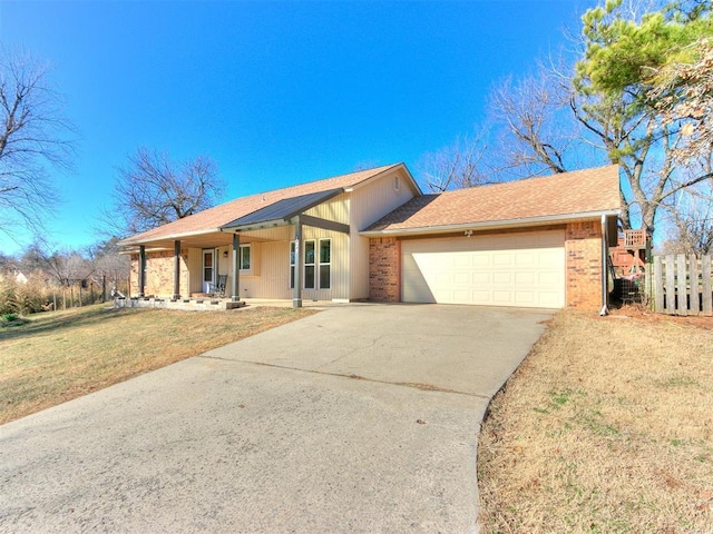 ranch-style home featuring an attached garage, brick siding, fence, concrete driveway, and a front yard