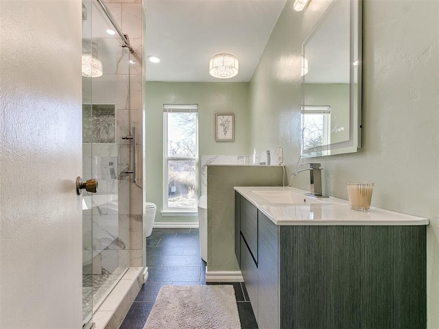 full bathroom featuring a stall shower, vanity, toilet, and baseboards