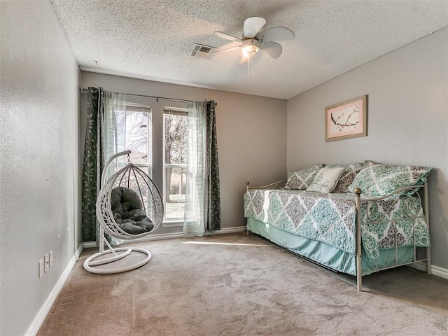 carpeted bedroom featuring a textured ceiling, a textured wall, visible vents, and baseboards