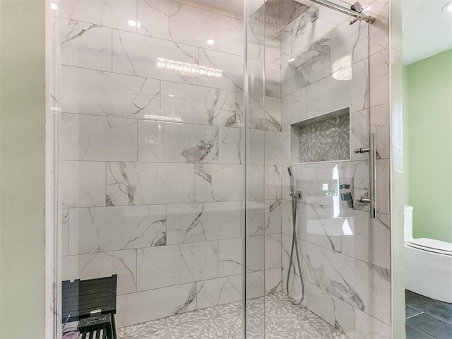 bathroom featuring toilet and a marble finish shower