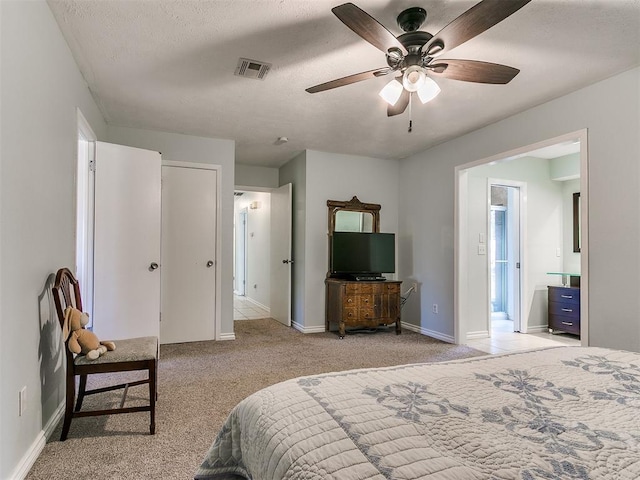 bedroom with a textured ceiling, carpet floors, a ceiling fan, visible vents, and baseboards