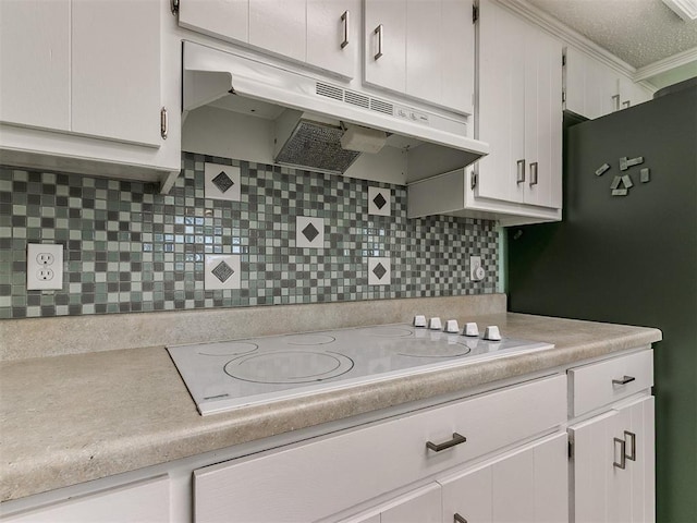 kitchen with under cabinet range hood, decorative backsplash, electric cooktop, and light countertops