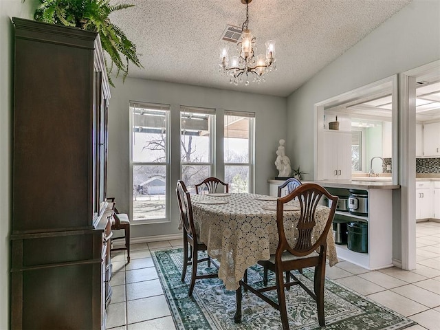 dining room with a notable chandelier, vaulted ceiling, visible vents, and light tile patterned floors