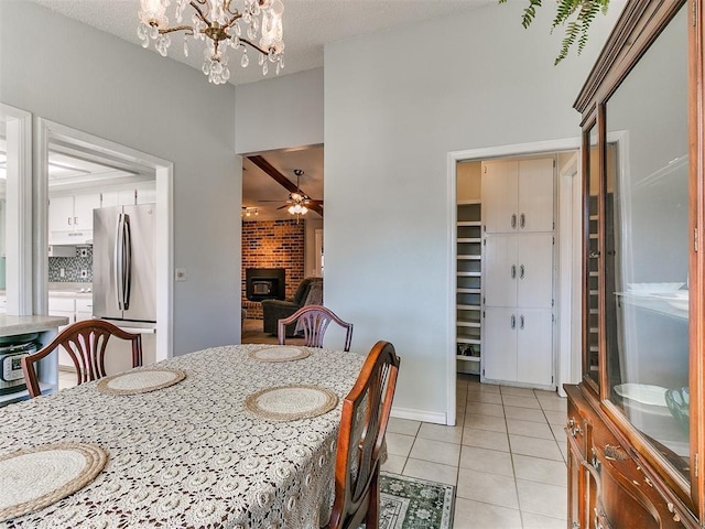 dining room featuring light tile patterned floors, a fireplace, a textured ceiling, and ceiling fan with notable chandelier