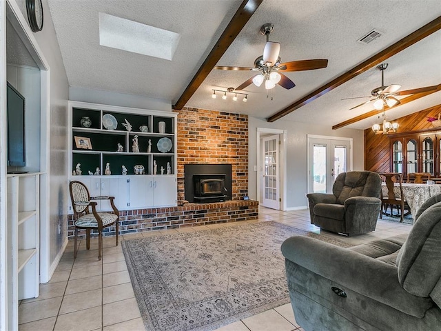 living room with a textured ceiling, light tile patterned floors, wooden walls, visible vents, and french doors