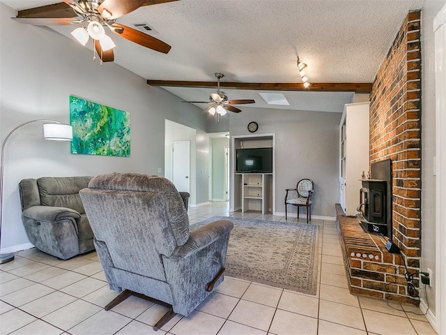 living room with a wood stove, vaulted ceiling with beams, a textured ceiling, and light tile patterned floors