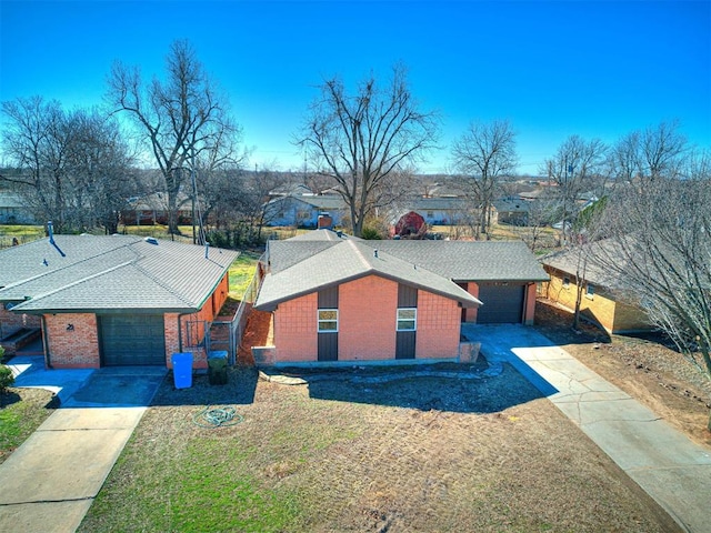 view of front facade with a shingled roof, concrete driveway, brick siding, and a garage