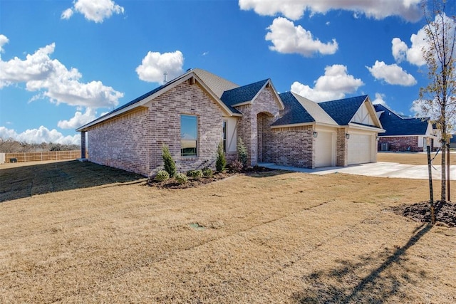 view of front of house with brick siding, a shingled roof, an attached garage, driveway, and a front lawn