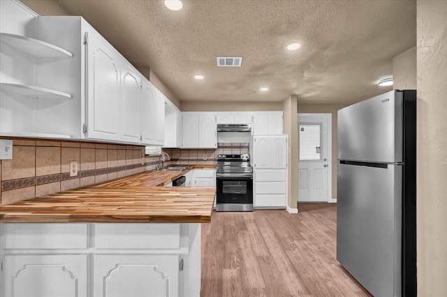 kitchen with visible vents, stainless steel appliances, under cabinet range hood, wooden counters, and a sink