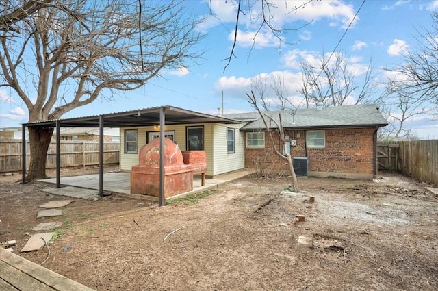 view of front of home with brick siding, a patio, a fenced backyard, and central AC unit