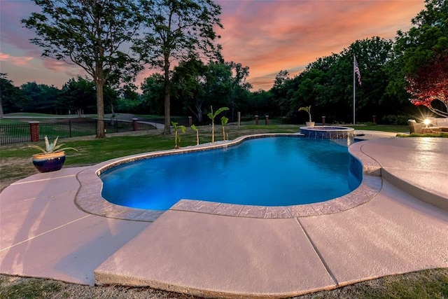 view of pool with a patio, a lawn, fence, and a pool with connected hot tub